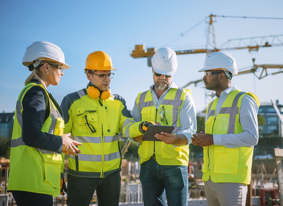 Insurance by Industry - Diverse Team of Specialists Use Tablet on Construction Site